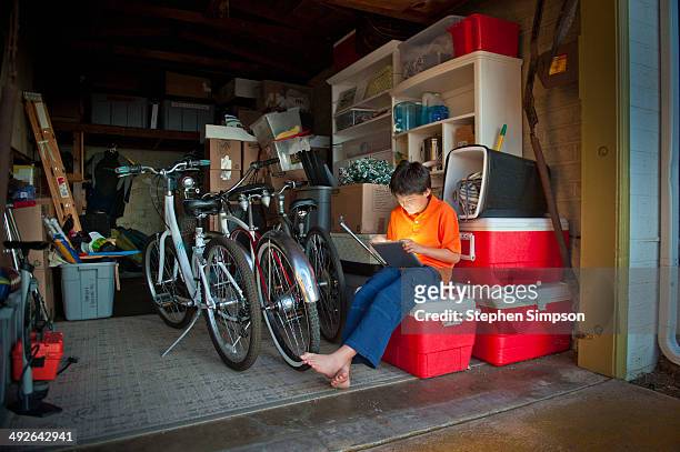 boy in garage on his tablet computer - san diego homes stock pictures, royalty-free photos & images