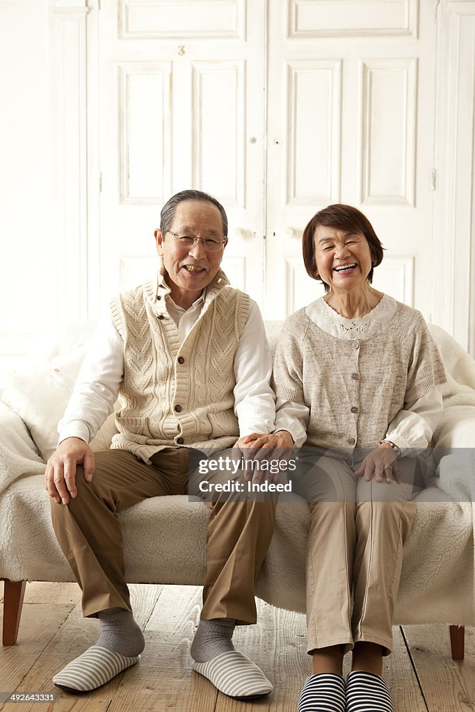 Happy senior couple sitting on sofa