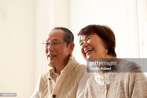 happy senior couple smiling, looking away - japanese senior couple stockfoto's en -beelden