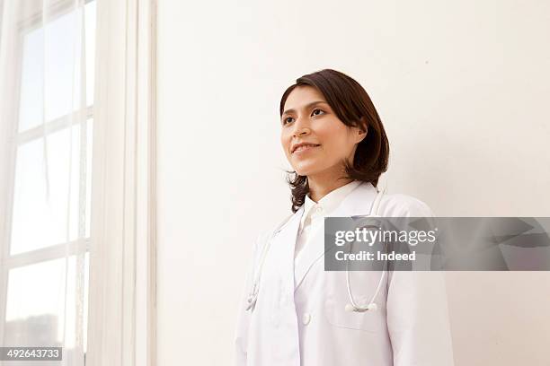 portrait of female doctor with stethoscope, low angle view - low confidence stock pictures, royalty-free photos & images