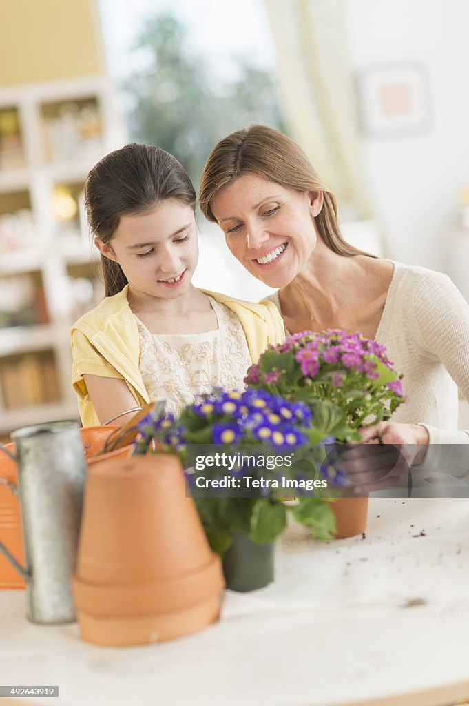 Girl (8-9) and mother potting flowers, Jersey City, New Jersey, USA