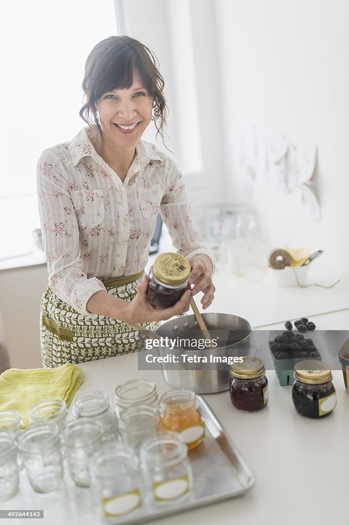 Woman making preserves in kitchen, Jersey City, New Jersey, USA