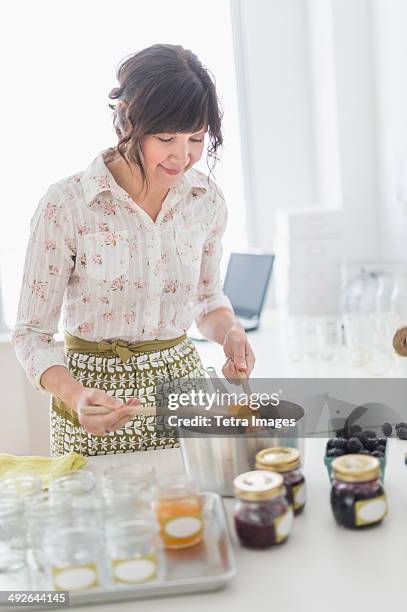 woman making preserves in kitchen, jersey city, new jersey, usa - marmelade machen stock-fotos und bilder