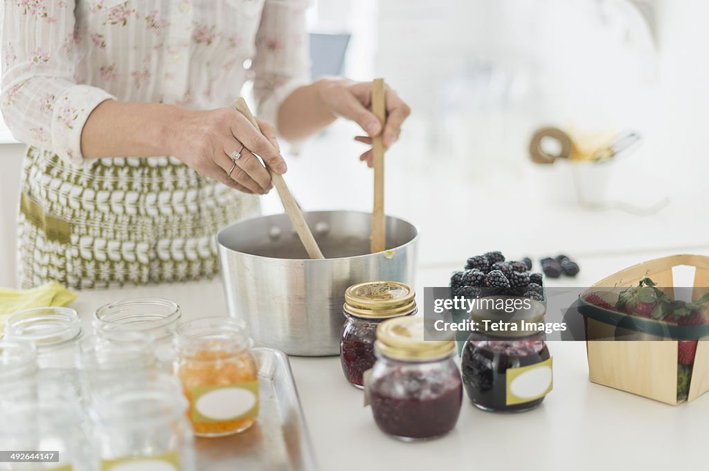 Midsection of woman making preserves in kitchen, Jersey City, New Jersey, USA