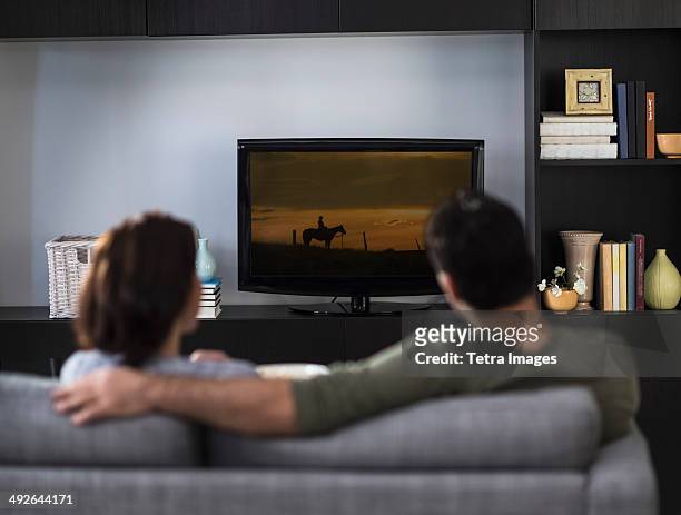 rear view of couple watching tv, jersey city, new jersey, usa - couple tv stock-fotos und bilder