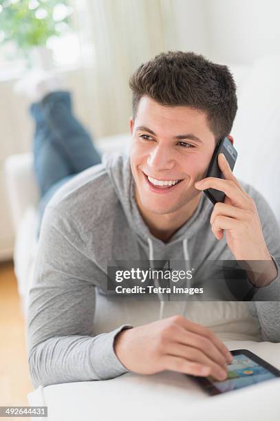 young man using tablet and talking by phone, jersey city, new jersey, usa - spiky hair stock pictures, royalty-free photos & images