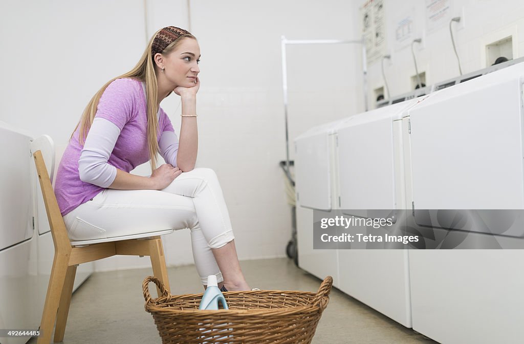 Woman waiting in laundromat, Jersey City, New Jersey, USA