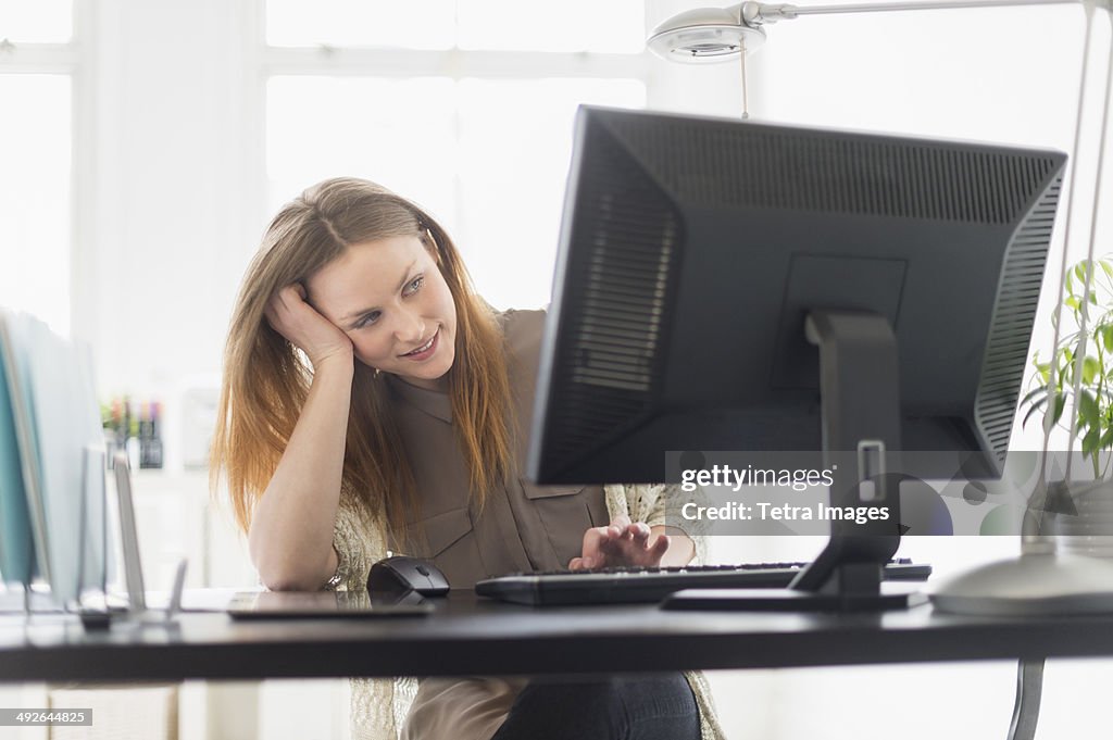 Portrait of young woman working on computer in office, Jersey City, New Jersey, USA