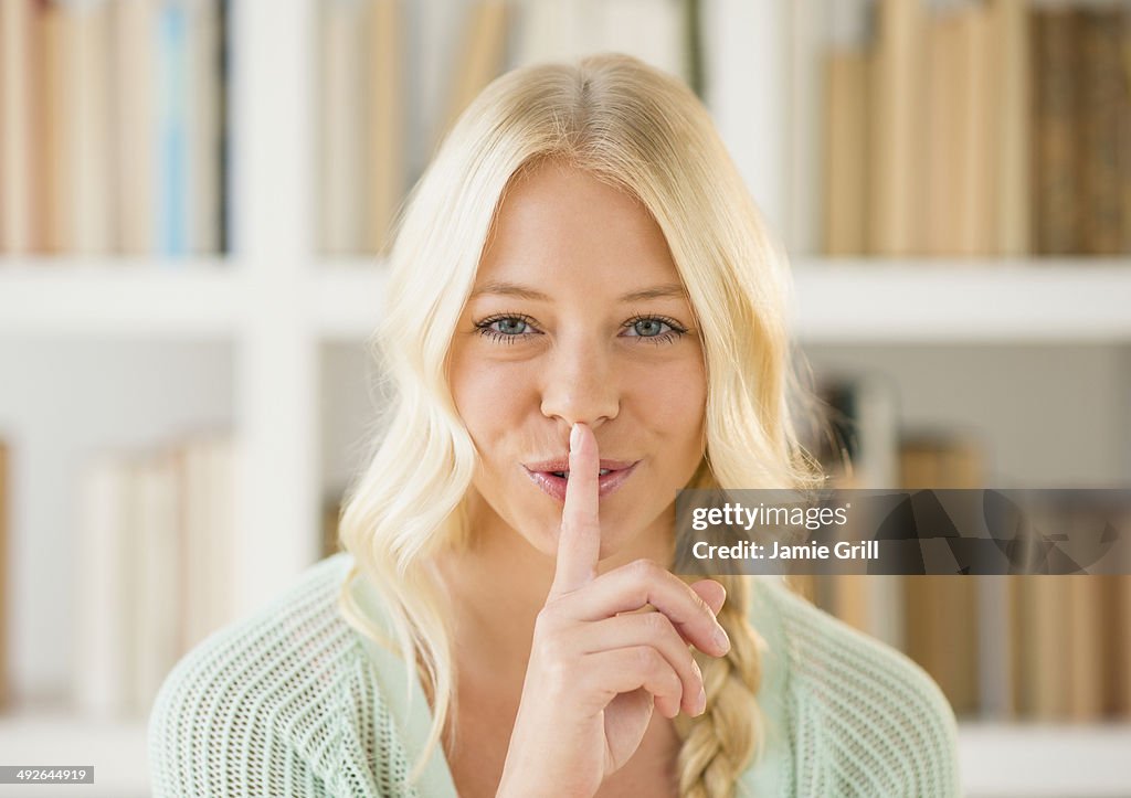 Portrait of woman with finger on lips, Jersey City, New Jersey, USA