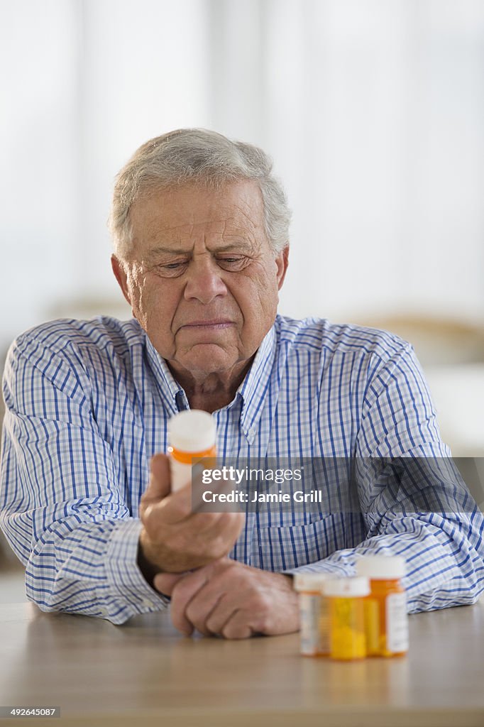Senior man holding pill bottle, Jersey City, New Jersey, USA