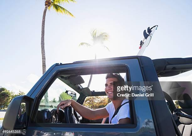 young man driving car, jupiter, florida, usa - jupiter florida fotografías e imágenes de stock
