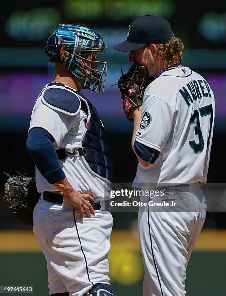 Starting pitcher Brandon Maurer of the Seattle Mariners gets a visit from catcher John Buck against the Tampa Bay Rays at Safeco Field on May 14,...