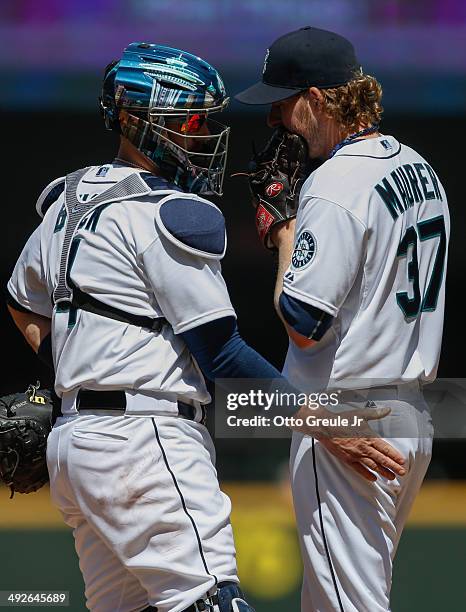 Starting pitcher Brandon Maurer of the Seattle Mariners gets a visit from catcher John Buck against the Tampa Bay Rays at Safeco Field on May 14,...