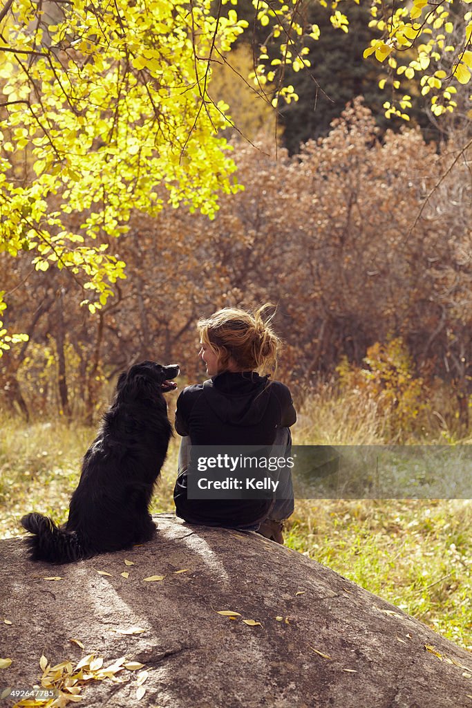 Woman and her collie sitting on stone, Colorado, USA