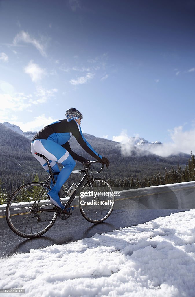 Man riding bike in winter mountains, British Columbia, Canada