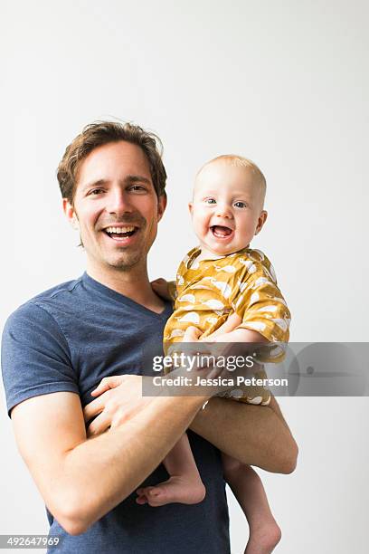 studio portrait of father with baby son (2-5 months) - baby white background foto e immagini stock