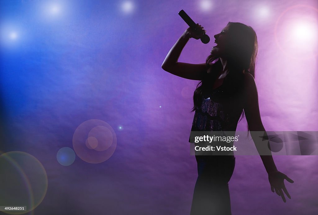 Silhouette of female singer on stage