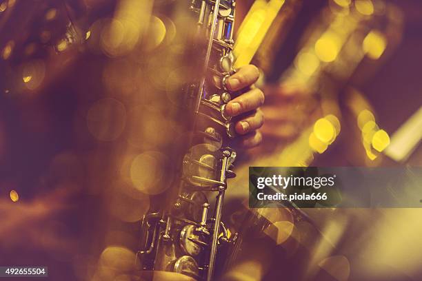 saxophone players playing live music - bandje stockfoto's en -beelden