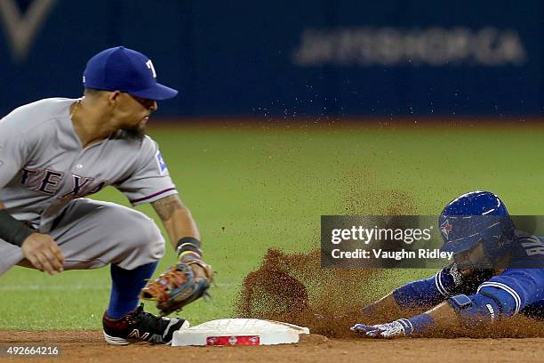 Jose Bautista of the Toronto Blue Jays slides safely into second base ahead of the tag by Rougned Odor of the Texas Rangers as Bautista gets a RBI...