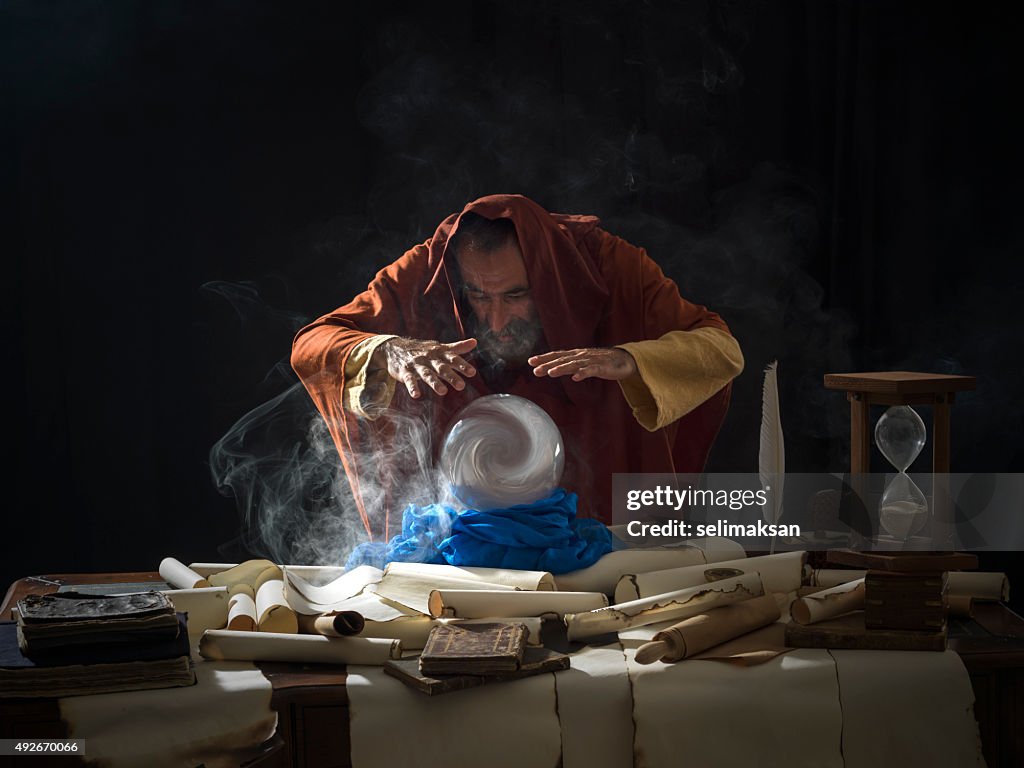 Fortune teller in fantastical costume using crystal ball