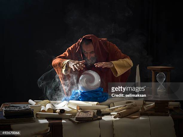 fortune teller in fantastical costume using crystal ball - magician stock pictures, royalty-free photos & images
