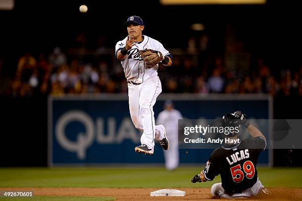 Everth Cabrera of the San Diego Padres completes a double play against Ed Lucas of the Miami Marlins at Petco Park on May 9, 2014 in San Diego,...