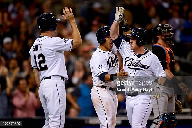 Seth Smith and Everth Cabrera congratulate Jedd Gyorko of the San Diego Padres after hitting a grand slam in the game against the Miami Marlins at...