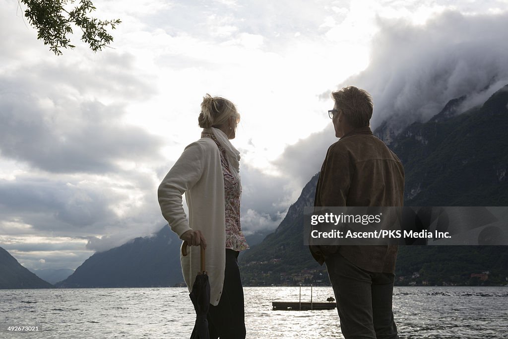 Couple look out across lake as storm passes