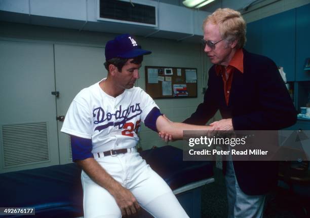 Los Angeles Dodgers orthopedist Dr. Frank Jobe examines the elbow of Tommy John in trainer's room at Dodger Stadium. Dr. Jobe previously replaced the...