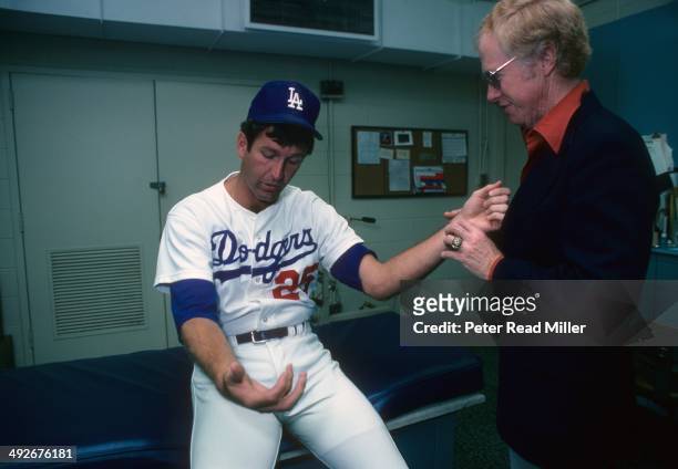 Los Angeles Dodgers orthopedist Dr. Frank Jobe examines the elbow of Tommy John in trainer's room at Dodger Stadium. Dr. Jobe previously replaced the...