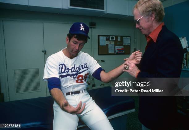 Los Angeles Dodgers orthopedist Dr. Frank Jobe examines the elbow of Tommy John in trainer's room at Dodger Stadium. Dr. Jobe previously replaced the...