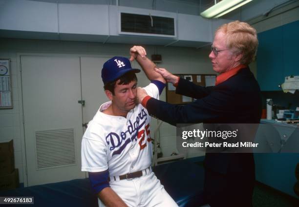 Los Angeles Dodgers orthopedist Dr. Frank Jobe examines the elbow of Tommy John in trainer's room at Dodger Stadium. Dr. Jobe previously replaced the...