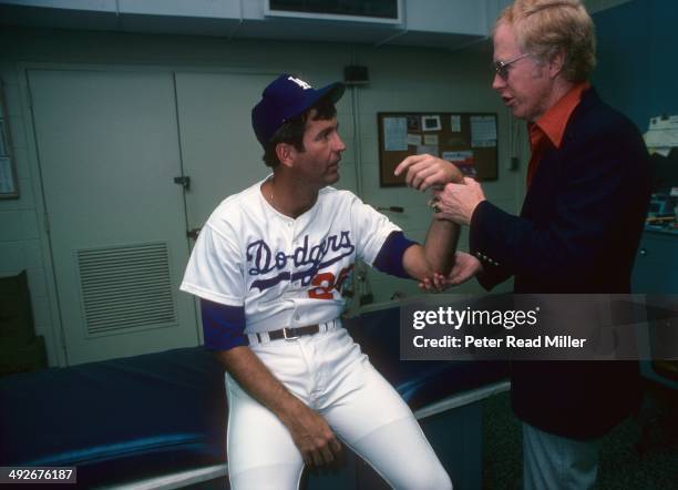 Los Angeles Dodgers orthopedist Dr. Frank Jobe examines the elbow of Tommy John in trainer's room at Dodger Stadium. Dr. Jobe previously replaced the...