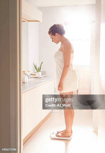 keeping tabs on her weight - woman weight scale stock pictures, royalty-free photos & images