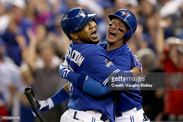 Troy Tulowitzki and Edwin Encarnacion of the Toronto Blue Jays celebrate after Encarnacion hits a sixth inning solo home run against the Texas...