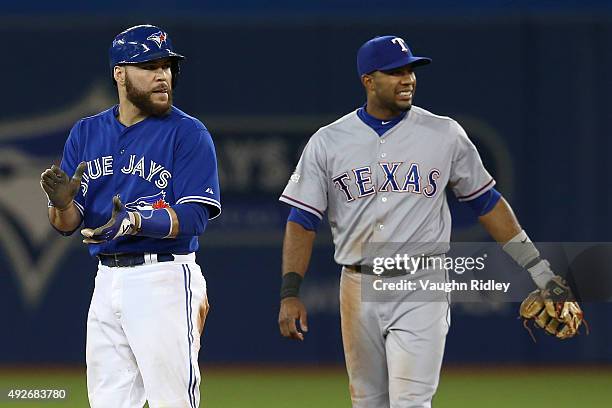 Elvis Andrus of the Texas Rangers is reacts as he is unable to catch the ball as Russell Martin of the Toronto Blue Jays slides into second safely in...