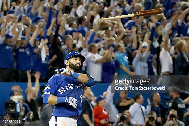 Jose Bautista of the Toronto Blue Jays throws his bat up in the air after he hits a three-run home run in the seventh inning against the Texas...