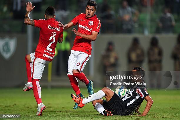 Patric of Atletico MG and Leo and Alisson Farias of Internacional battle for the ball during a match between Atletico MG and Internacional as part of...