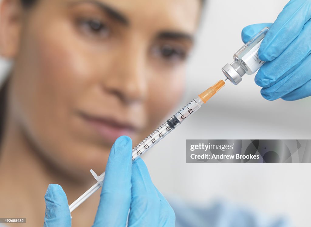 Close up of nurse preparing a syringe for an injection