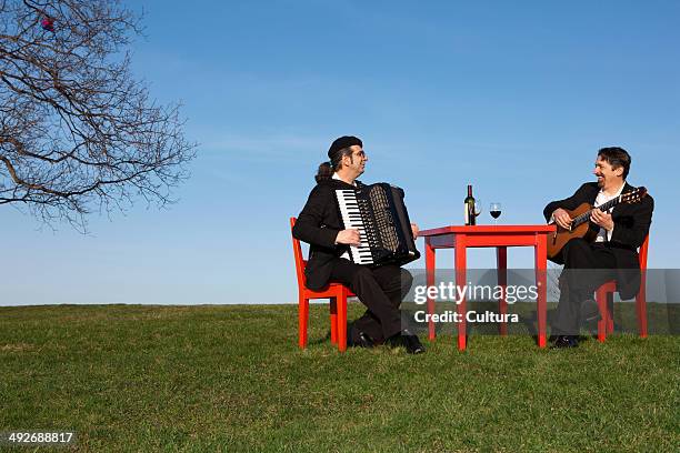 two men playing accordion and guitar outdoors - accordionist stock pictures, royalty-free photos & images