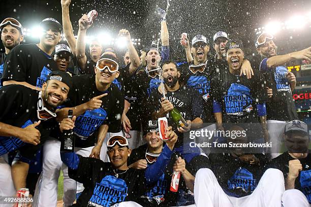 The Toronto Blue Jays pose for a team photo as they celebrate the 6-3 win against the Texas Rangers as Ben Revere jumps on top of the pile in game...