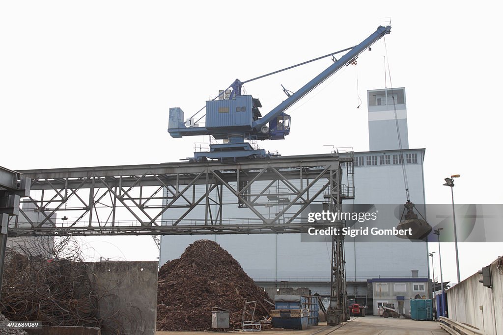 Pile of scrap and crane in port