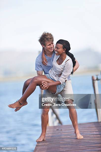 young couple of jetty, man lifting woman - knysna stock-fotos und bilder