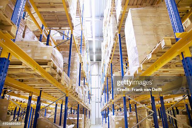 stacked shelves in distribution warehouse - tallo stock-fotos und bilder