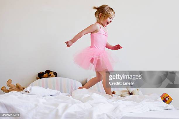 girl dressed as ballet dancer running on bed - tutú fotografías e imágenes de stock