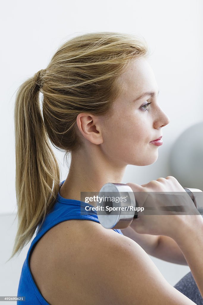 Young woman lifting weights