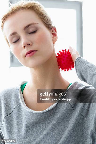 young woman using massage ball on neck - massage ball stock pictures, royalty-free photos & images