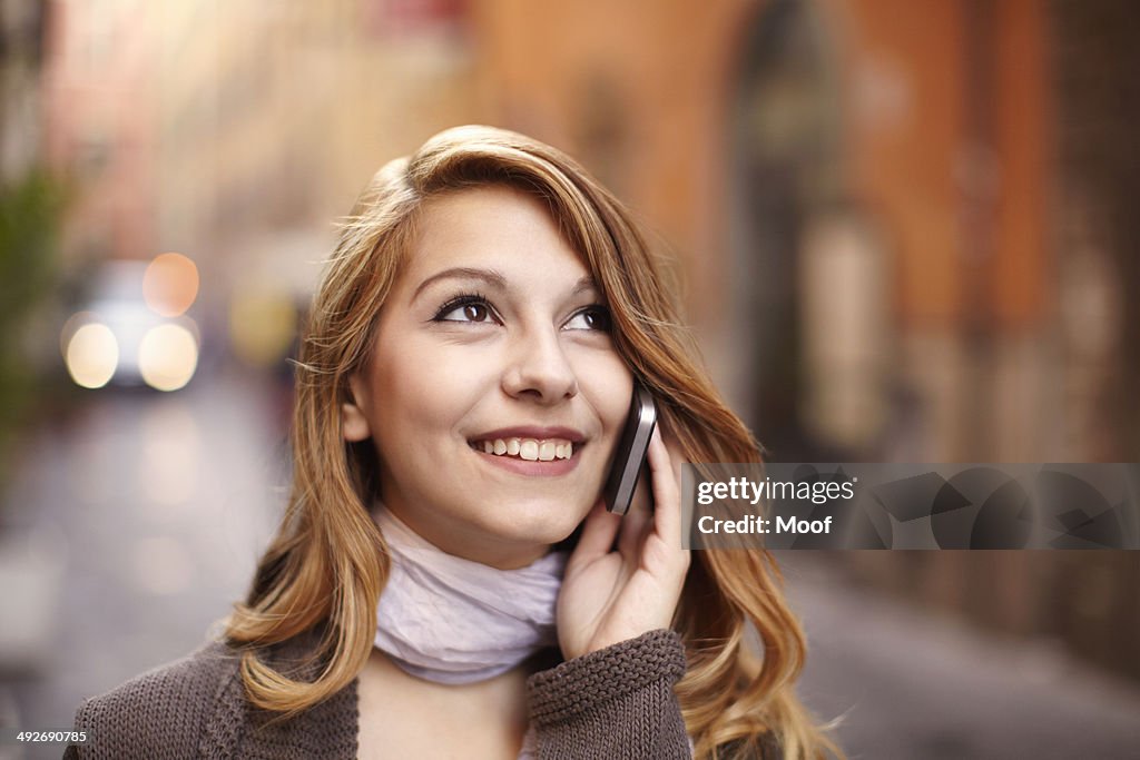 Young woman chatting on smartphone on Rome street, Italy