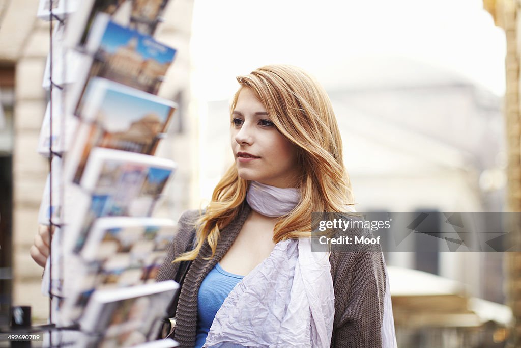 Young woman looking at postcards, Rome, Italy