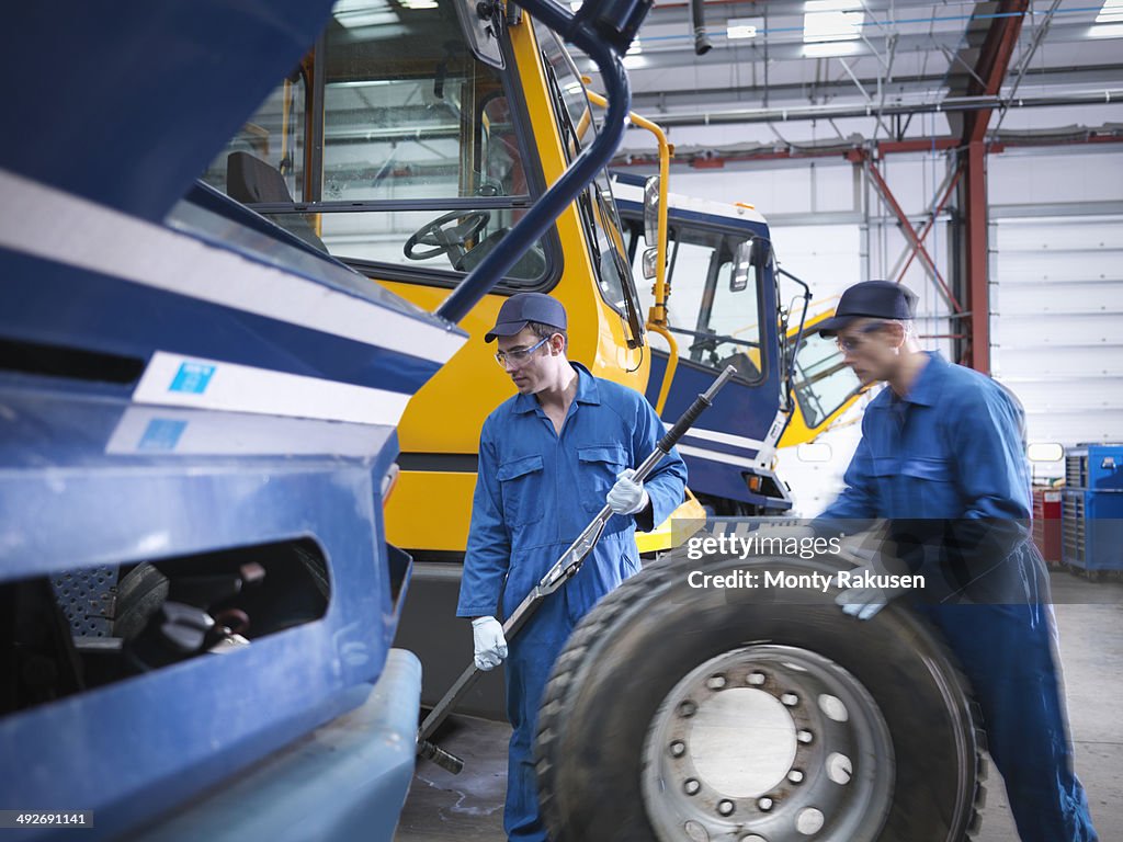 Engineers prepare to fix wheel in truck repair factory